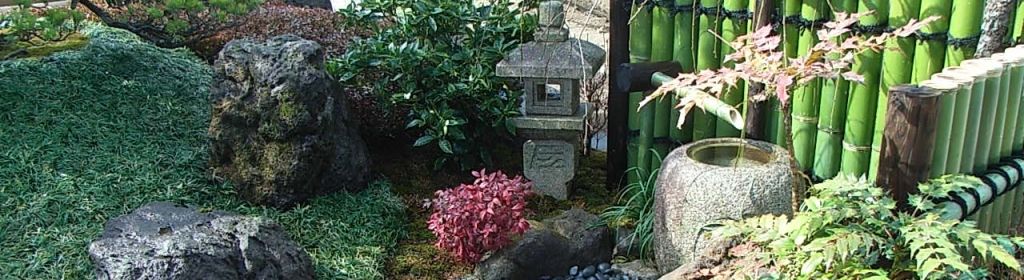 灯籠と水鉢、青竹垣のある和風庭園